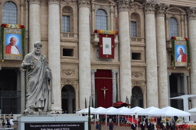 Fasada bazyliki św. Piotra w Rzymie z portretami papieży Jana Pawła II i Jana XXIII, w pierwszym planie posąg świętego Piotra z kluczem w dłoni